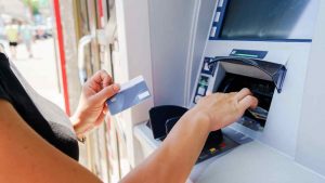 Donna preleva dei contanti ad uno sportello ATM - foto Corporate+ - SiciliaNews24.it